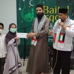 Aisyah Surya Salsabila Al-Amin kelas V bendahara LazismuKid’s dan Ilham Zaidan Robbani kelas III anggota pengurus LazismuKid’s menrahkan bantuan kemanusiaan Palestina (Basirun/PCMU. CO)