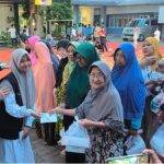 Foto Pj Darul Arqom Nurun Naharo dan chelsie kelas 5A beserta Warga Dhuafa.